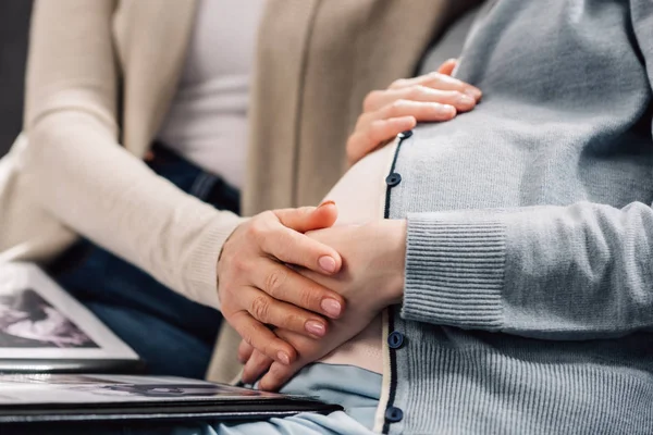 Gravid kvinna med mor på soffa — Stockfoto