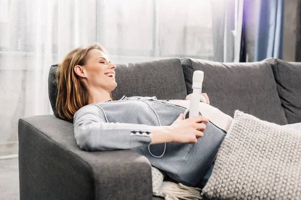 Pregnant woman with headphones on her belly — Free Stock Photo