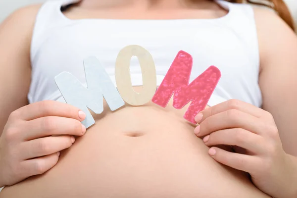 Pregnant woman with mom word — Stock Photo, Image