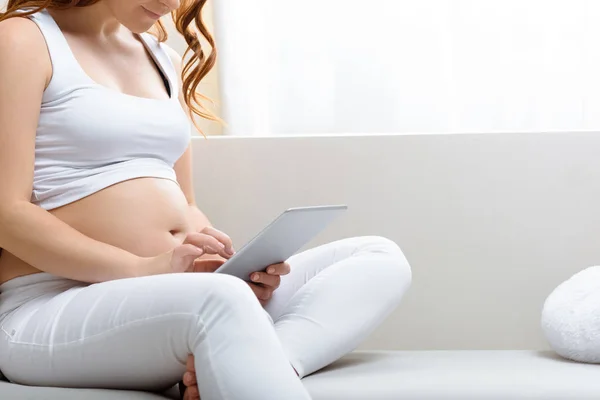 Gravid kvinna med digital tablet — Stockfoto