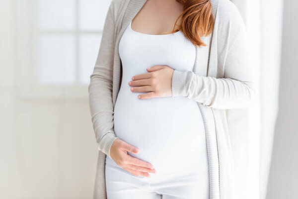 pregnant woman touching her belly 