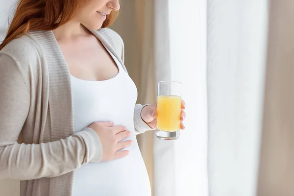 Mulher grávida com copo de suco — Fotografia de Stock