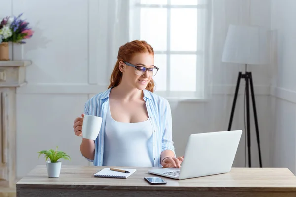 Mujer embarazada usando el ordenador portátil — Foto de Stock