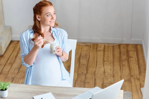 Pregnant woman eating yoghurt — Stock Photo, Image