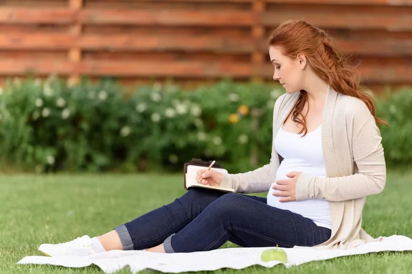 Gravid kvinna skriva i dagboken — Stockfoto