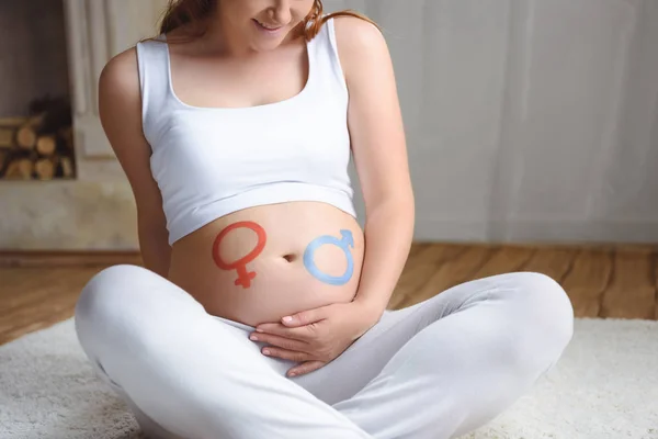 Schwangere Frau mit Symbolen für Jungen oder Mädchen — Stockfoto