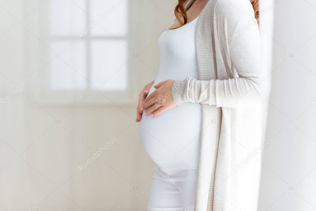 pregnant woman touching her belly 
