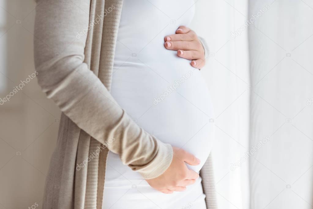 pregnant woman touching her belly 