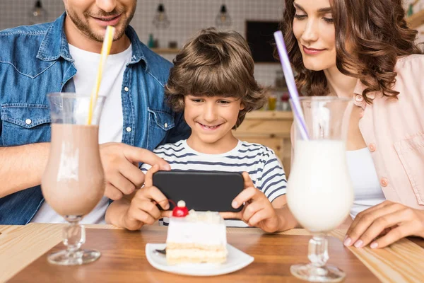 Young family taking photo of dessert — Free Stock Photo