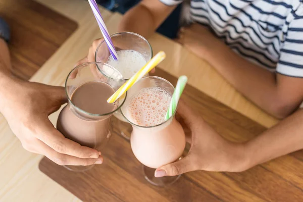 family clinking with glasses of milkshakes