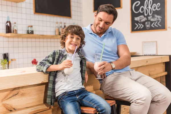 Zoon en vader drinken milkshakes — Stockfoto