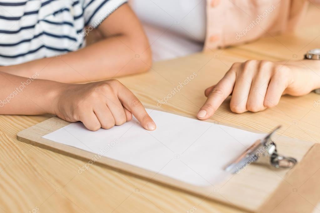 woman and boy pointing at blank paper