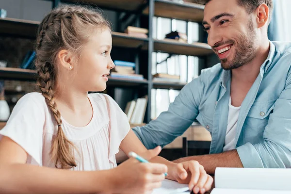 Father doing homework with daughter — Free Stock Photo