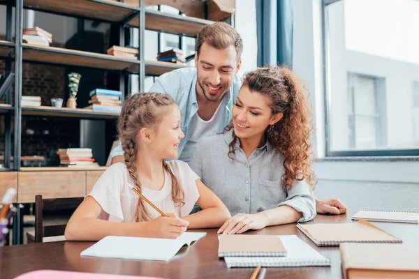 Padres haciendo la tarea con su hija — Foto de Stock