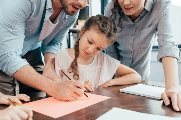 Föräldrar att hjälpa sin dotter med läxor — Stockfoto