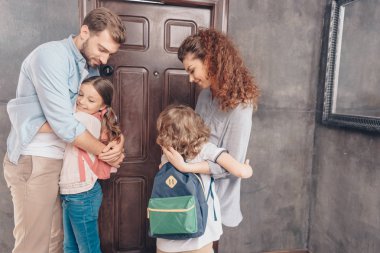 Ebeveynler çocukları okula gitmeden önce sarıl.