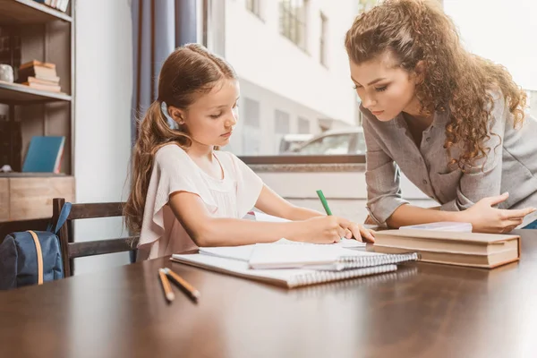 Moeder en dochter samen huiswerk maken — Stockfoto