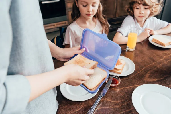 Mother packing lunch for children — Stock Photo, Image