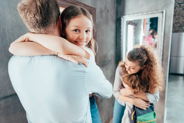 Föräldrar krama barnen innan skolan — Stockfoto