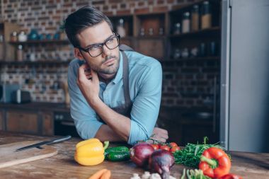 thoughtful young man at kitchen clipart