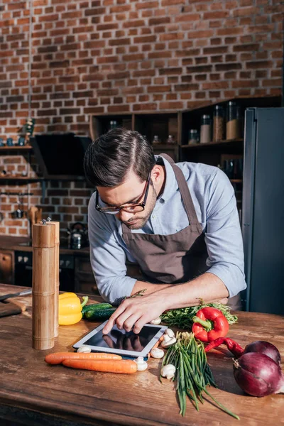 Hombre cocina con la tableta — Foto de Stock