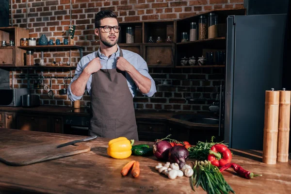 Young man in apron on kitchen — Stock Photo, Image