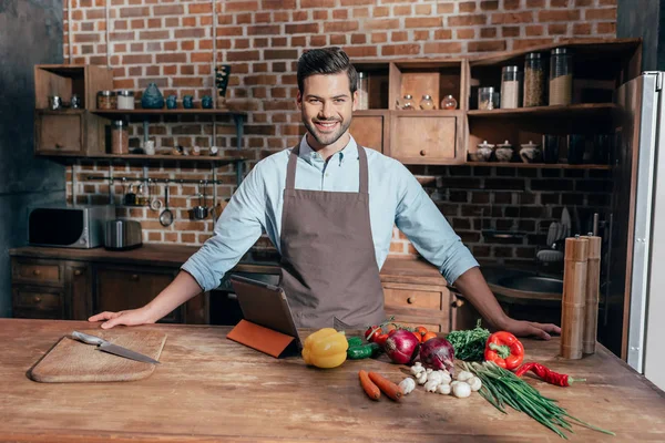 Jeune homme dans tablier sur la cuisine — Photo