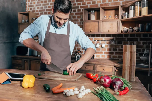 Mann schneidet Gemüse — Stockfoto