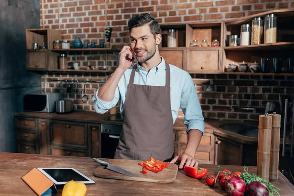 Hombre cocinar y hablar por teléfono —  Fotos de Stock