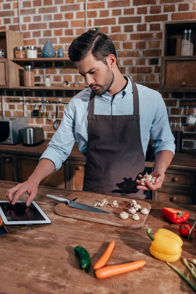 Hombre cocina con la tableta — Foto de Stock