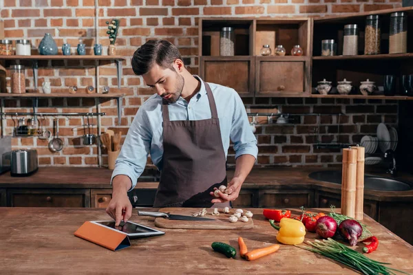 Homem cozinhar com comprimido — Fotografia de Stock