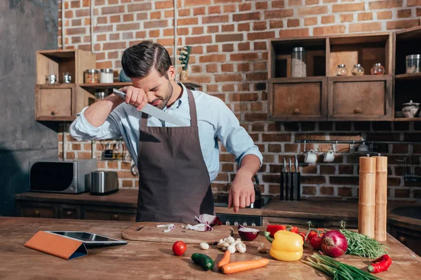 Junger Mann schneidet Zwiebel — Stockfoto