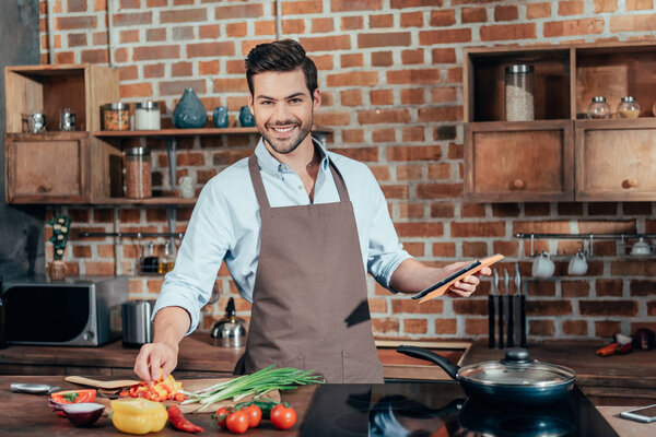 man cooking with tablet