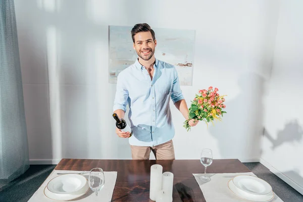 Homem com buquê de flores e vinho — Fotografia de Stock