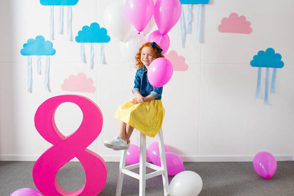 girl with balloons at birthday party