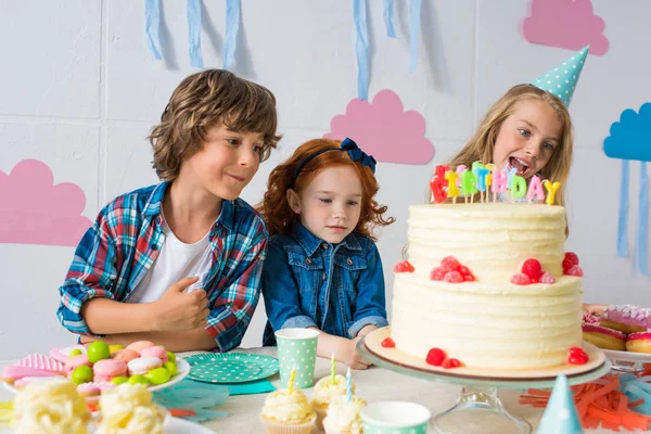 Crianças comendo doces na mesa de aniversário — Fotografia de Stock