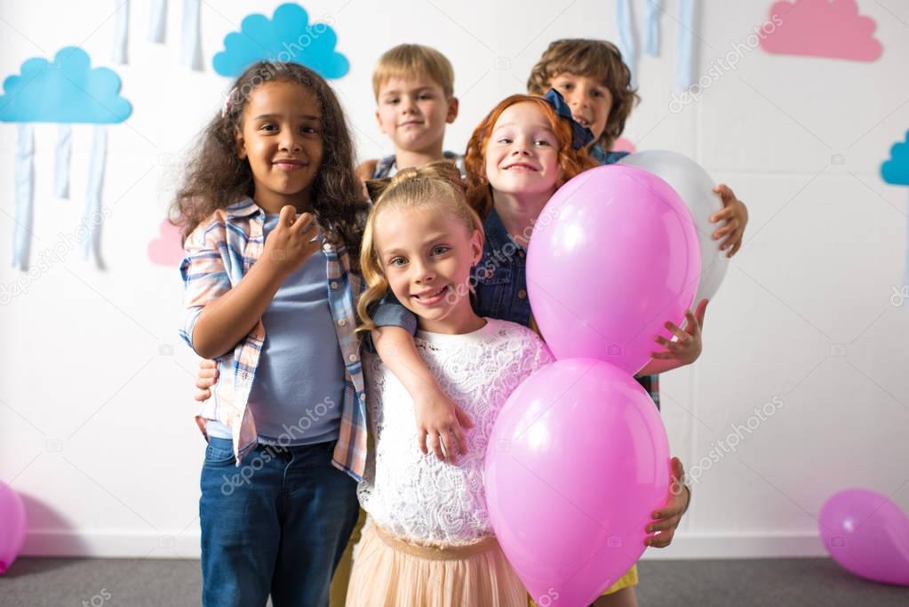 multiethnic kids with balloons at birthday party