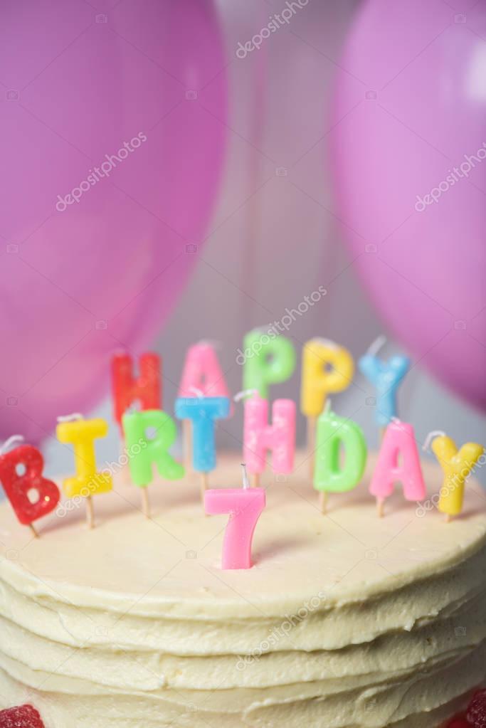 Close-up view of delicious birthday cake with number seven on top