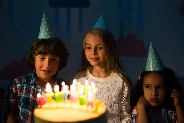 Дети смотрят на праздничный торт — стоковое фото