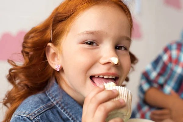 Chica comer cupcake — Foto de Stock