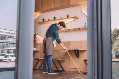 worker cleaning floor with sweep clipart