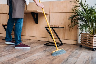 worker cleaning floor with broom clipart