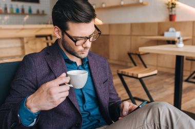 Kafede Smartphone kullanarak iş adamı