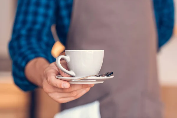 Barista trzymając filiżankę kawy — Zdjęcie stockowe