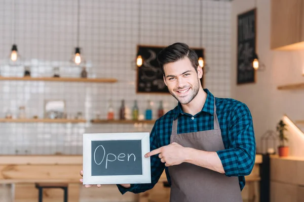 Barista pointing at chalkboard with open word — Stock Photo, Image