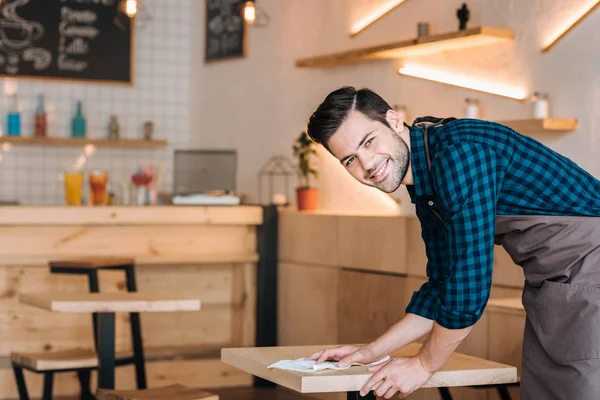 Arbeiter putzt Tisch im Café — Stockfoto