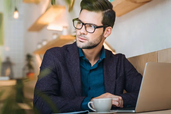 Uomo d'affari pensoso con computer portatile in caffè — Foto Stock