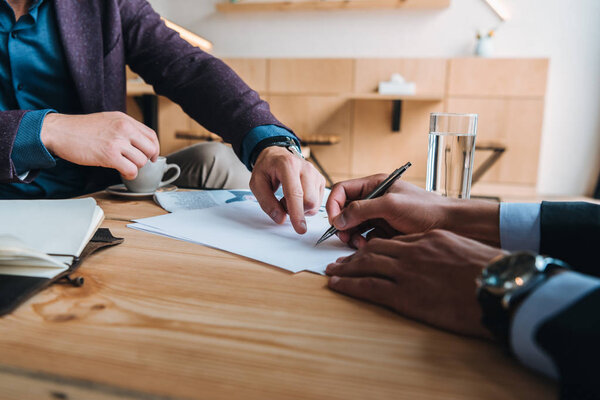 Hombres de negocios firmando contrato en reunión — Foto de Stock