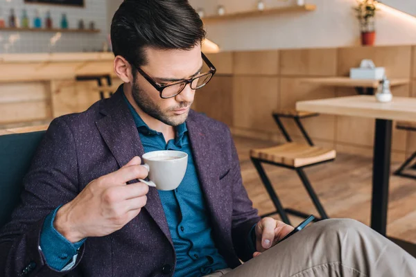 Hombre de negocios con teléfono inteligente en la cafetería —  Fotos de Stock