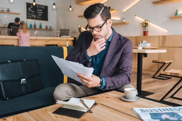 Affärsman gör pappersarbetet i café — Stockfoto